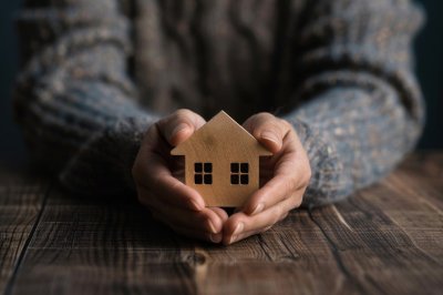 Person holding wooden toy house